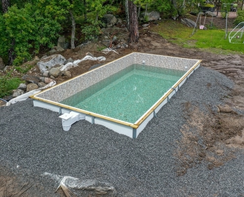 Anläggning av pool ovan mark med makadam runt omkring